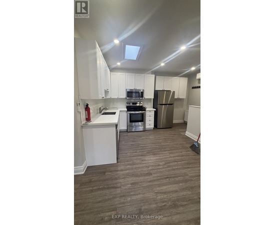A kitchen with white cabinets and a stove top oven.