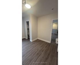 A room with wood flooring and white walls.