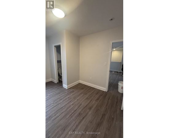 A room with wood flooring and white walls.