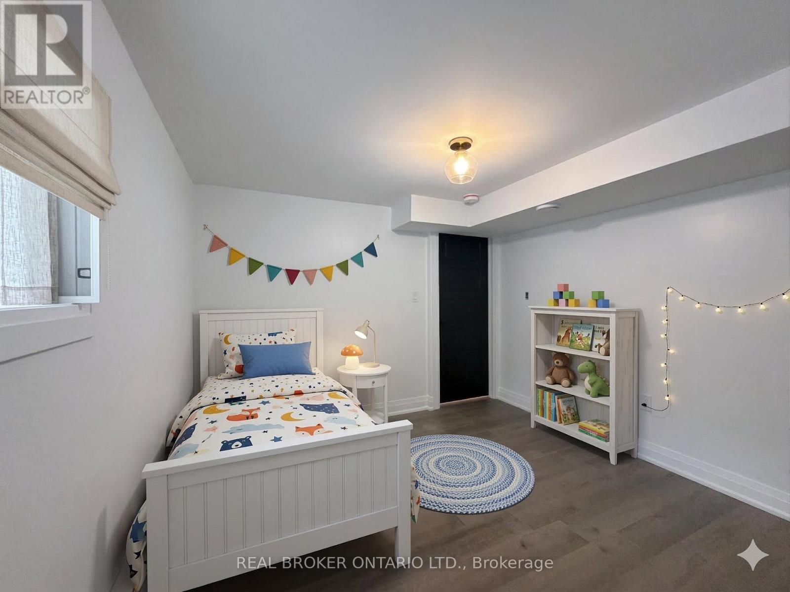 A bedroom with a bed, a bookcase, and a rug.