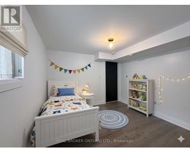 A bedroom with a bed, a bookcase, and a rug.