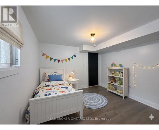 A bedroom with a bed, a bookcase, and a rug.