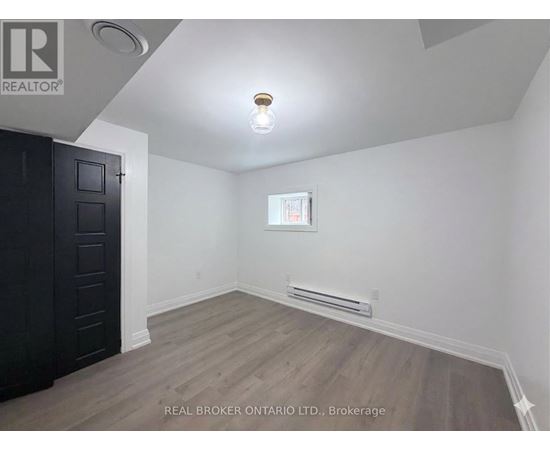 A room with a wooden floor and a window with a white frame.