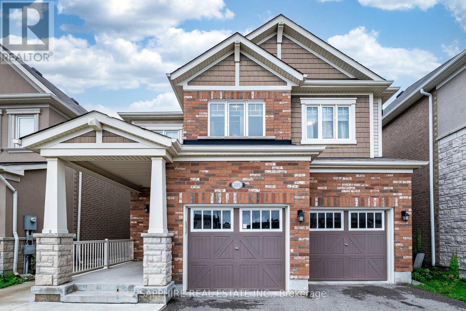 A two-story house with a garage and a brick facade.