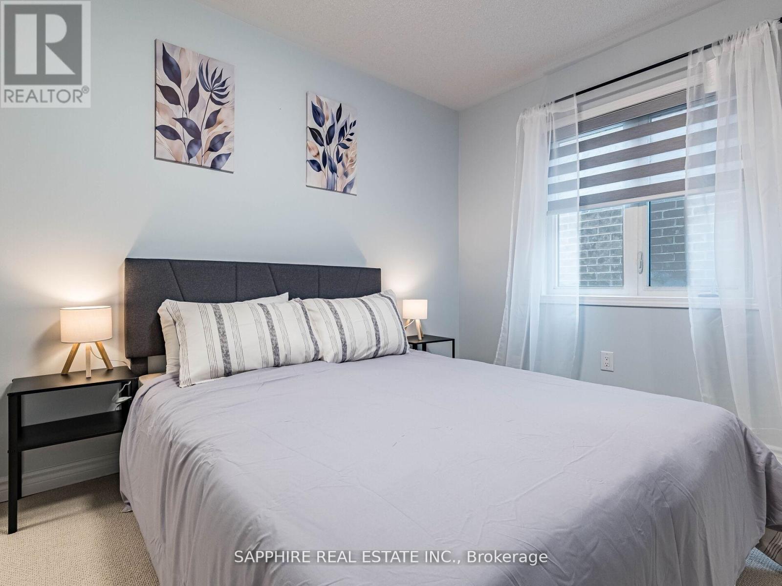 A bedroom with a large bed and two wall art pieces.