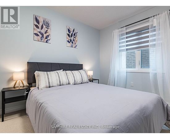 A bedroom with a large bed and two wall art pieces.