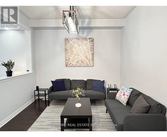 A living room with a grey couch and a brown coffee table.