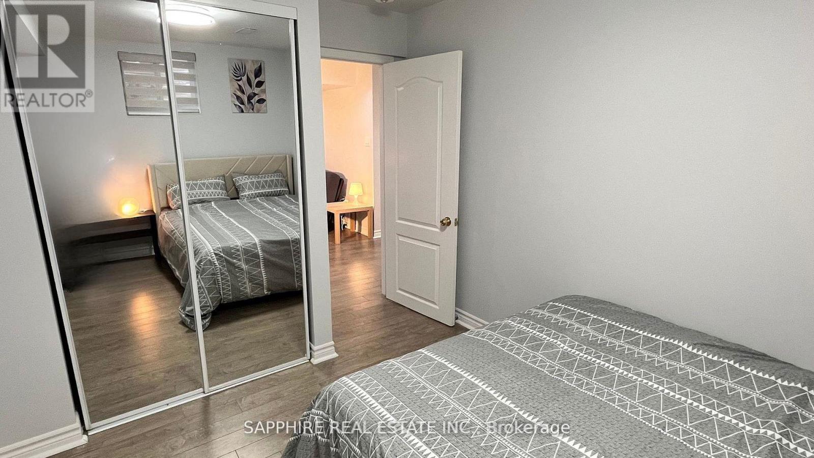 A bedroom with a bed and a mirror on the wall.