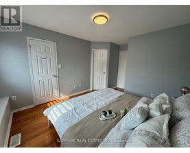 A bedroom with a bed in the middle and two doors on the wall.