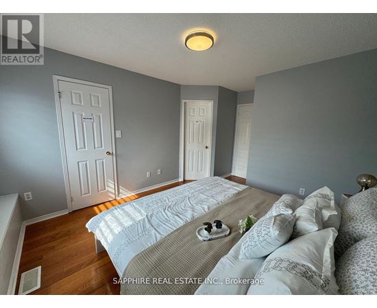 A bedroom with a bed in the middle and two doors on the wall.