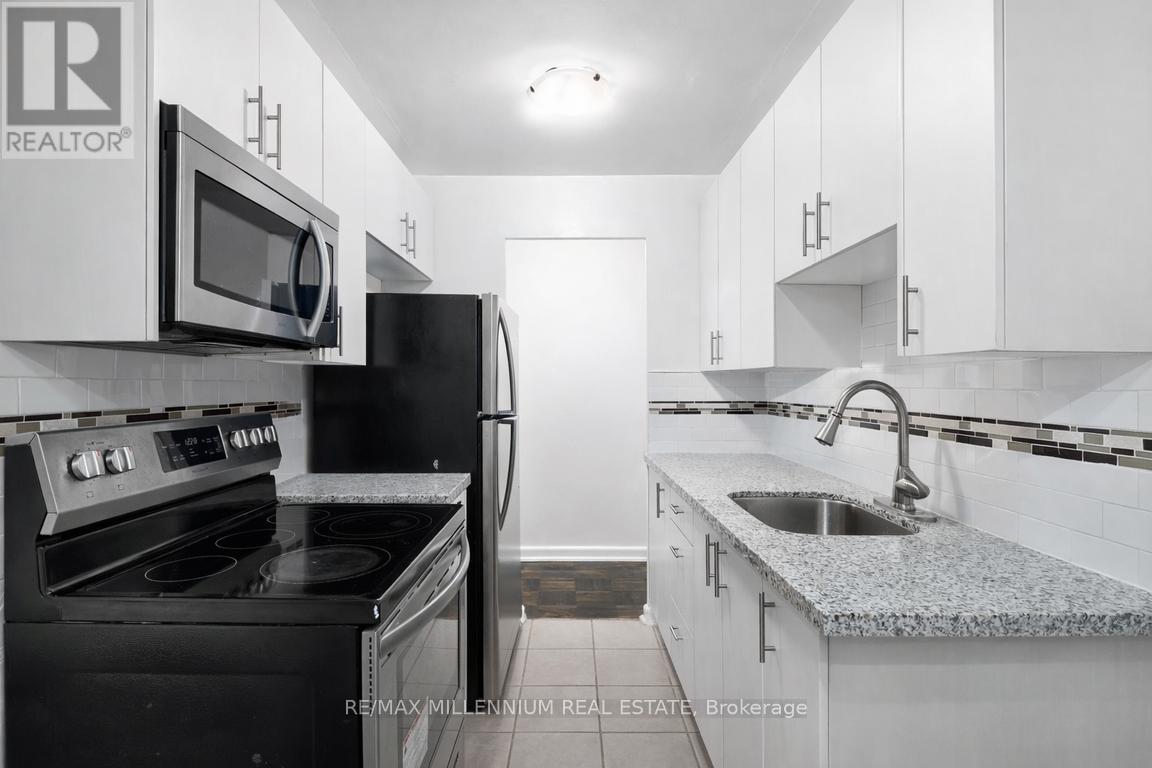 A kitchen with black appliances and white cabinets.