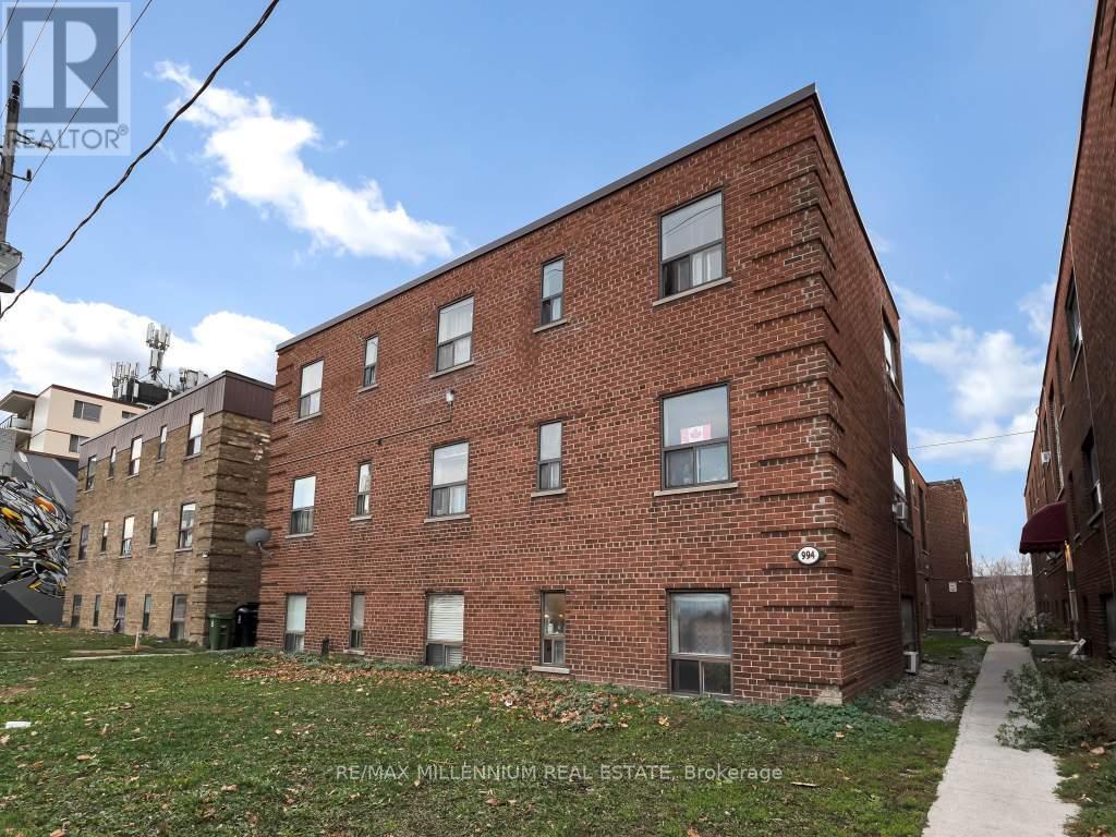 A red brick building with a sign that says RE/MAX Millennium Real Estate Brokerage.