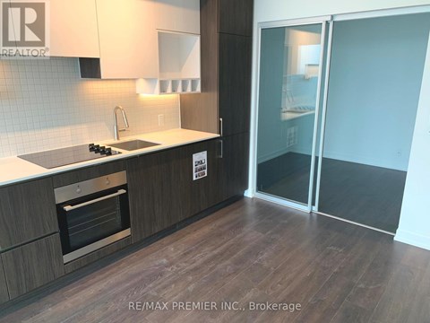 A modern kitchen with a stove top oven and a glass door cabinet.