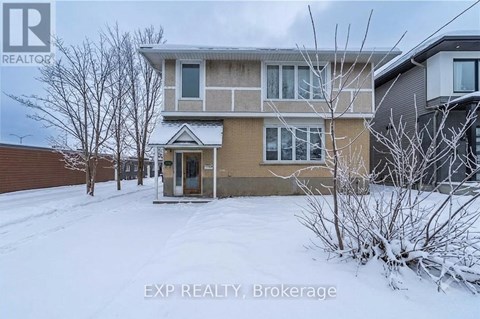 A house with snow on the ground and trees in front.