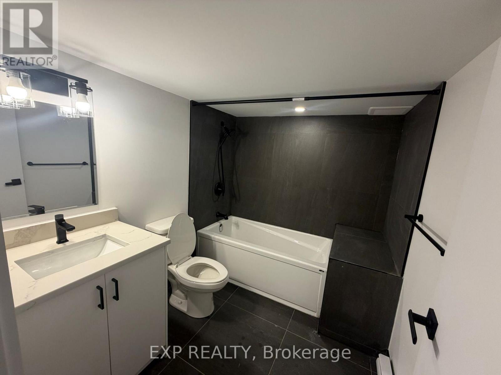 A bathroom with a toilet, sink, and bathtub.
