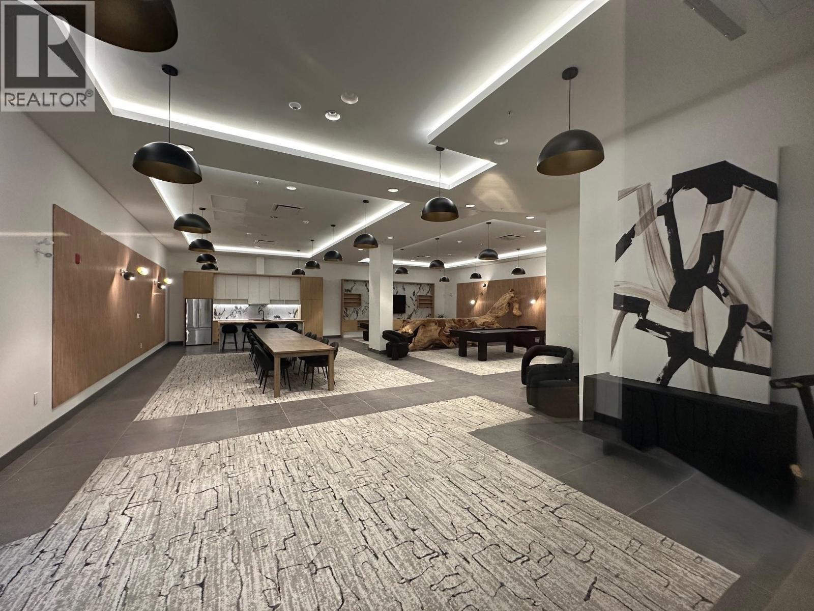 A large open space with a stone floor and a large abstract painting on the wall.
