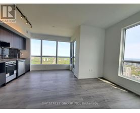 A spacious room with a view of the cityscape through large windows.