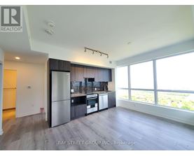 A spacious kitchen with a refrigerator, oven, and sink.