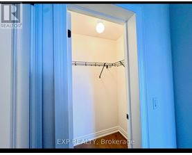 A small, empty room with a closet and a light on.