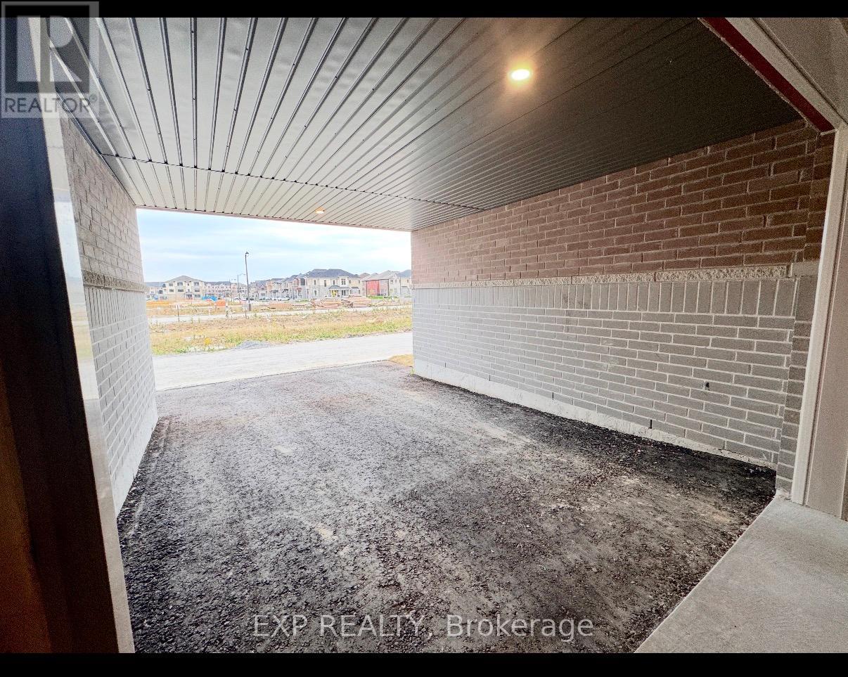 A large, empty garage with a brick wall and a concrete floor.