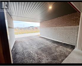 A large, empty garage with a brick wall and a concrete floor.