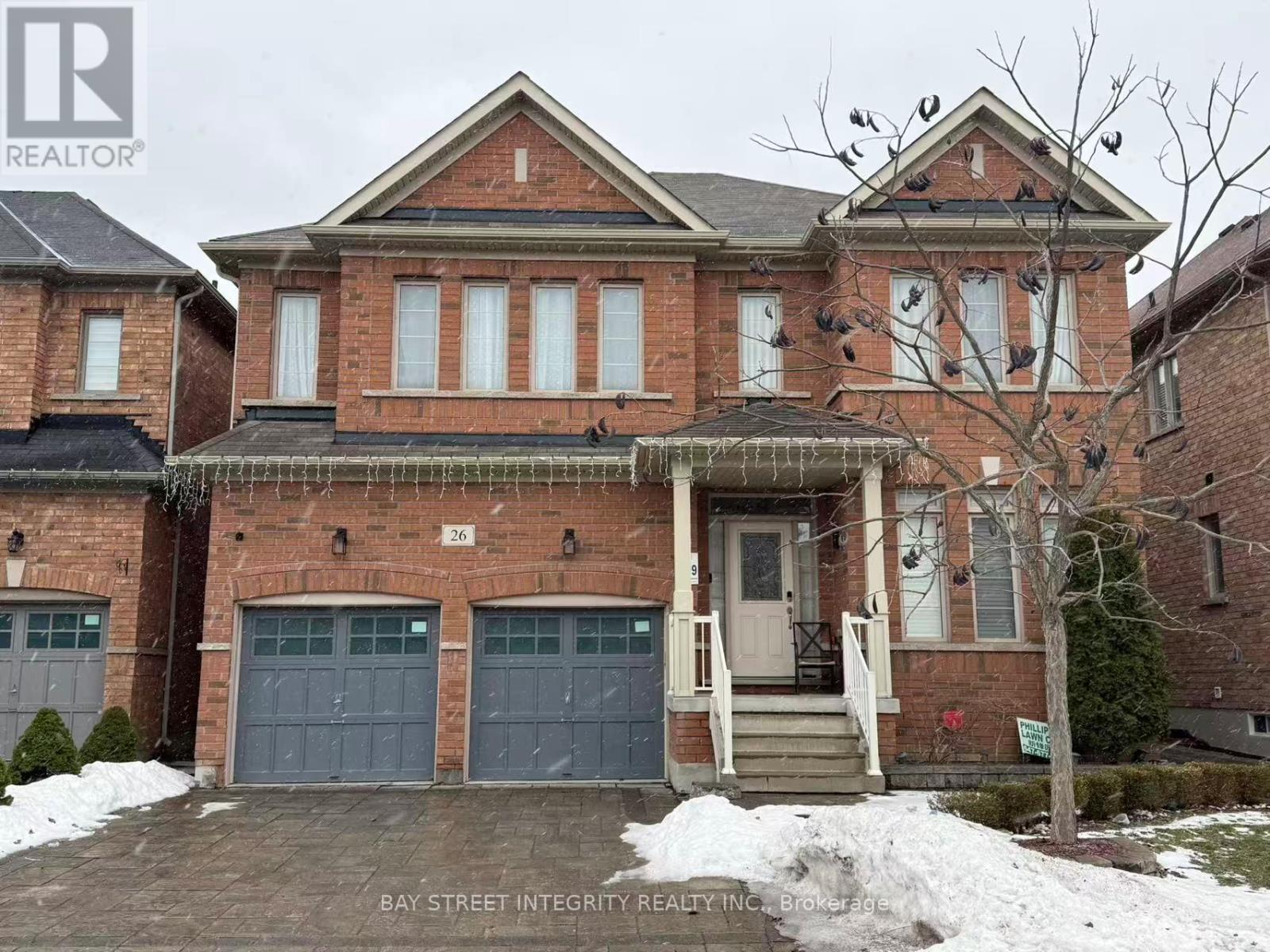 A large brick house with a bay window and a garage door.