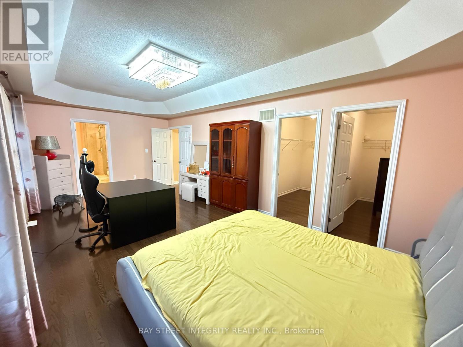 A bedroom with a bed, desk, and chair.