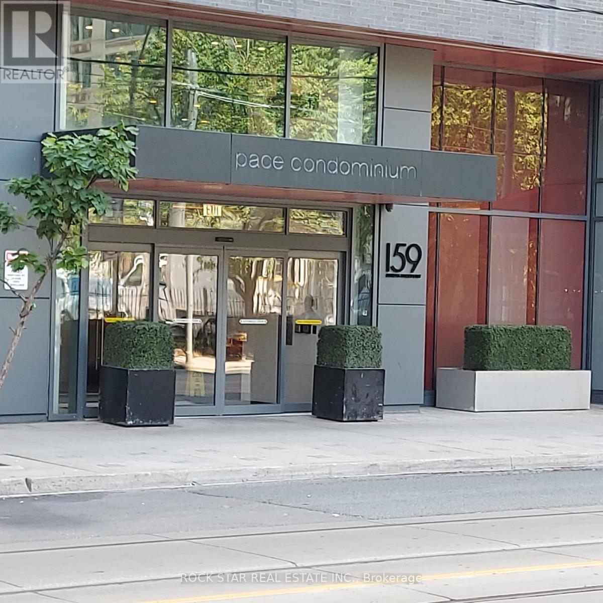 The front of a building with a glass door and a sign that says "Pace Condominium".