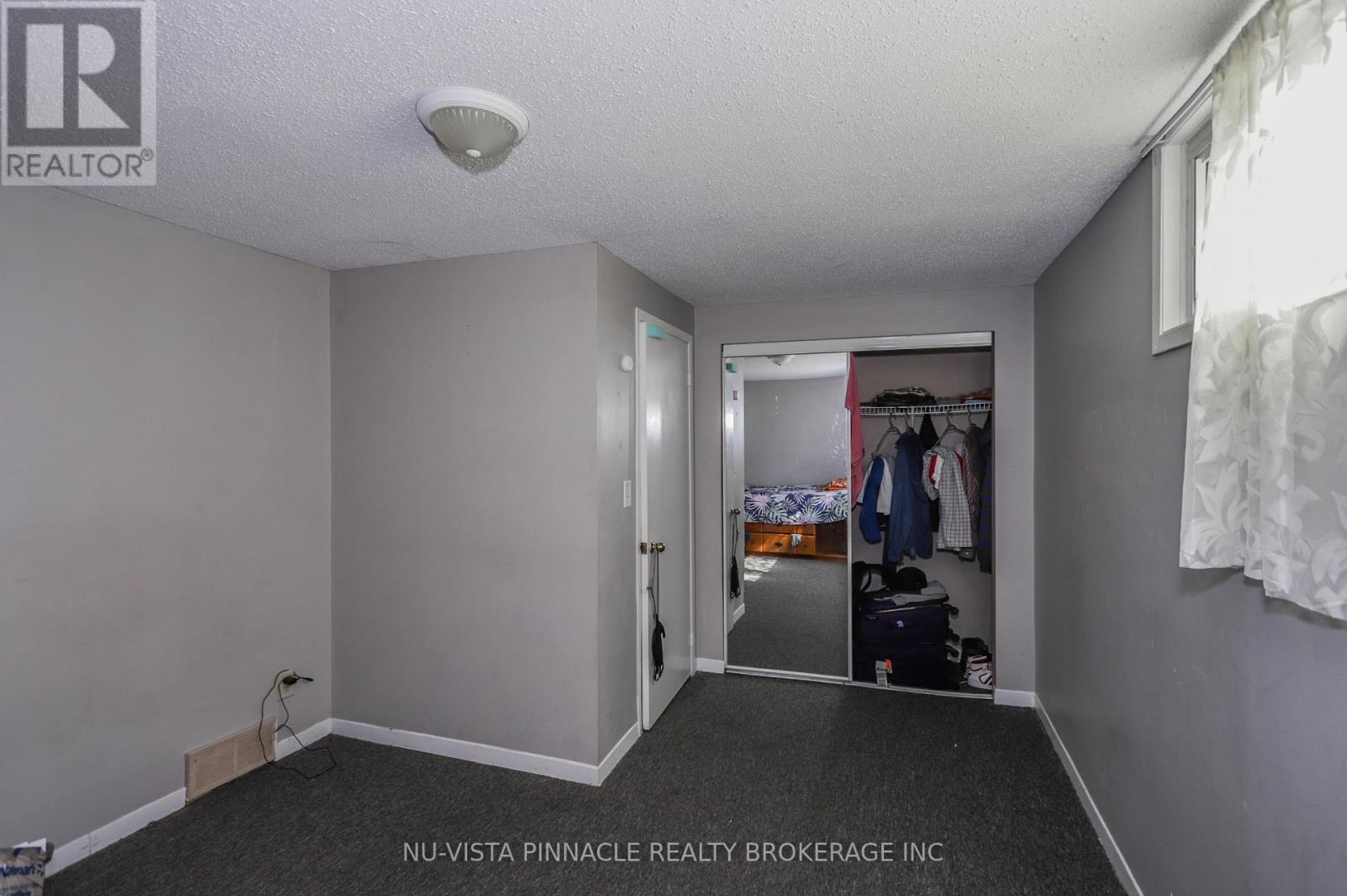 A bedroom with a closet and a bed in the other room.