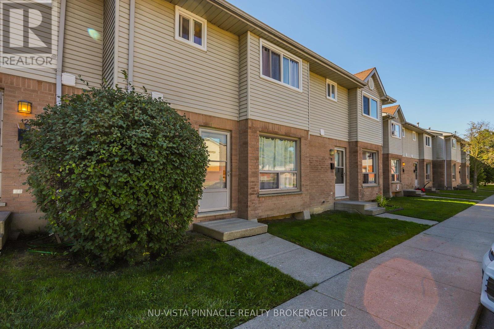 A row of houses with the sign NU-VISTA PINNACLE REALTY BROKERAGE INC.