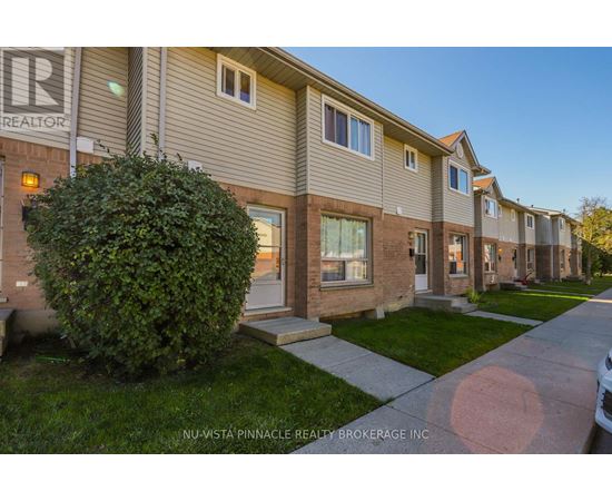 A row of houses with the sign NU-VISTA PINNACLE REALTY BROKERAGE INC.