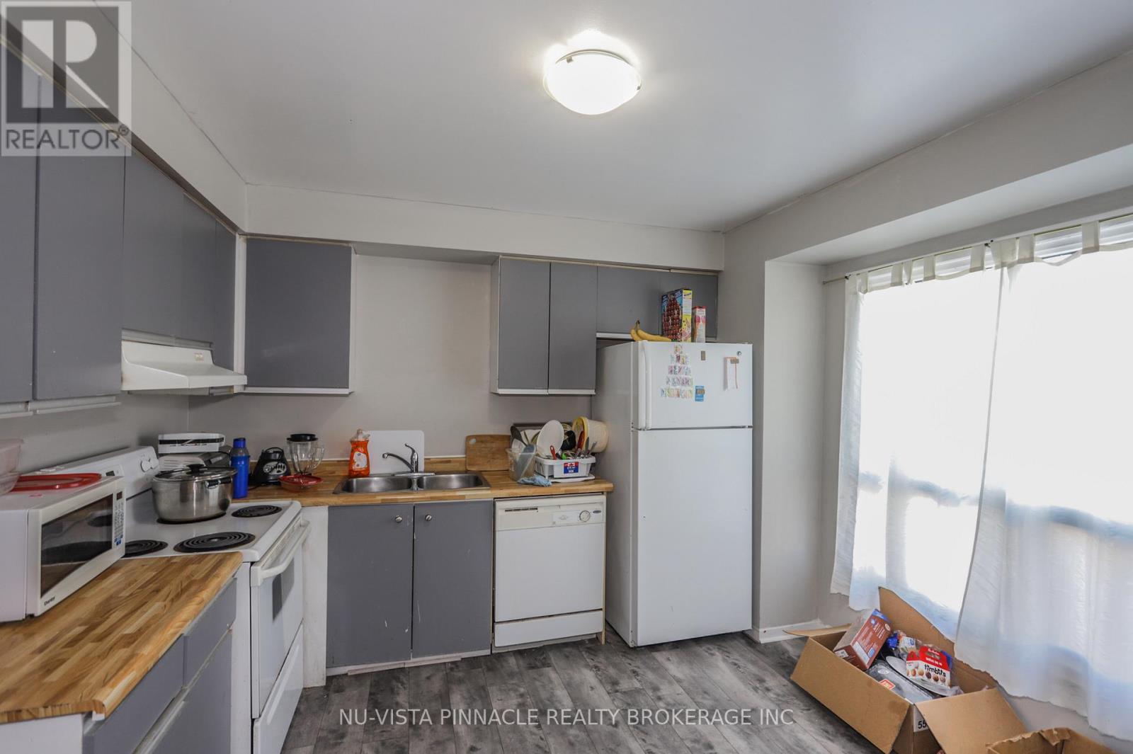 A kitchen with white appliances and a wooden counter top.