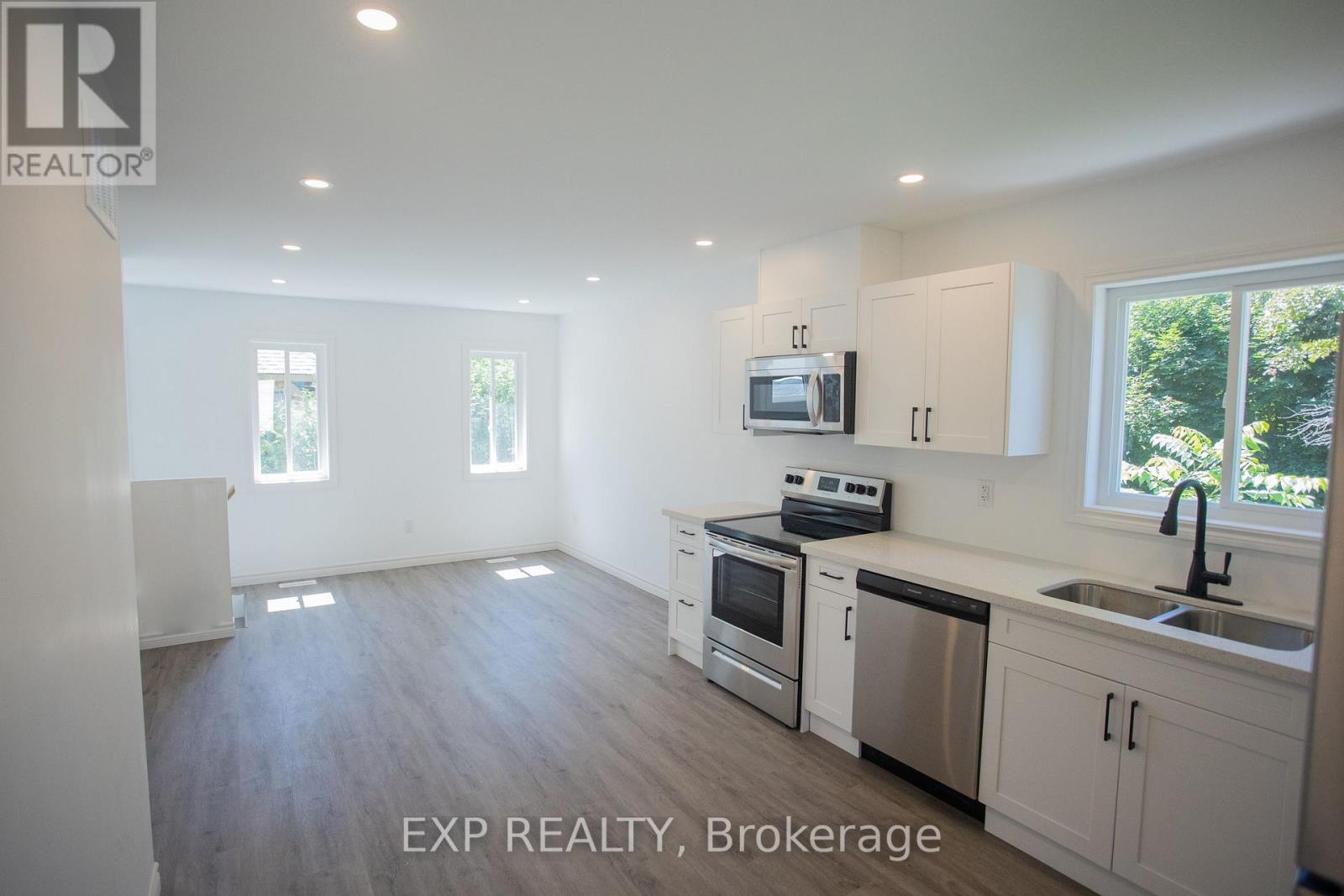 A kitchen with white cabinets and a microwave above the stove.