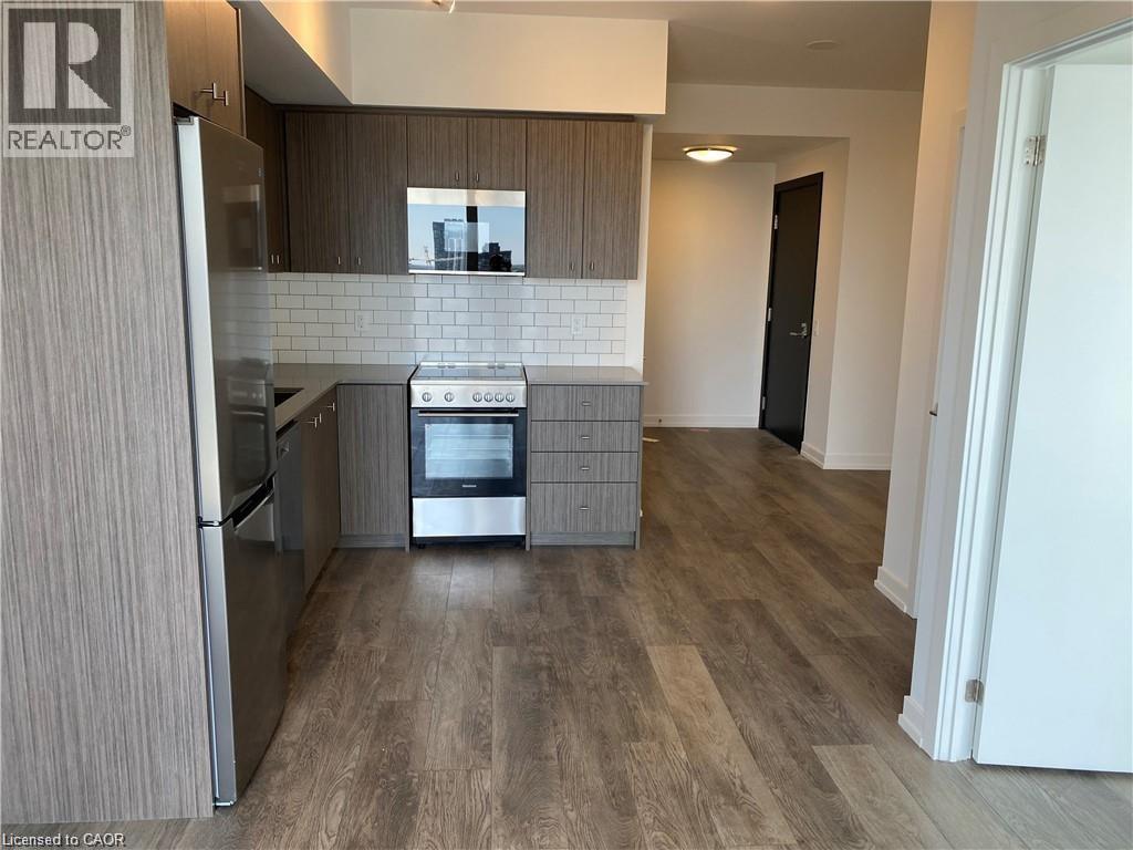 A modern kitchen with a refrigerator, oven, and microwave.