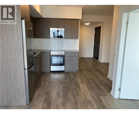 A modern kitchen with a refrigerator, oven, and microwave.