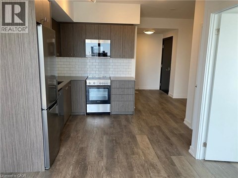 A modern kitchen with a refrigerator, oven, and microwave.