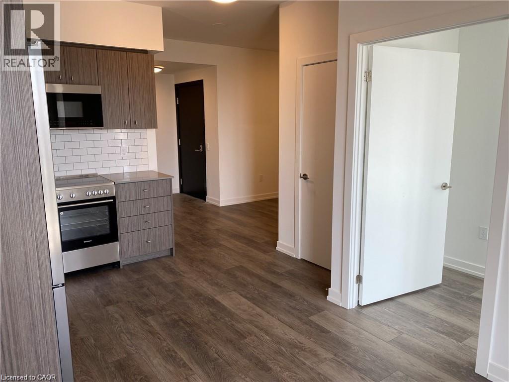 A kitchen with a microwave, oven, and refrigerator.