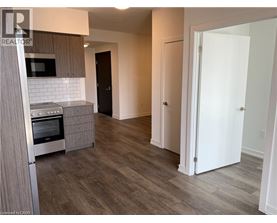 A kitchen with a microwave, oven, and refrigerator.