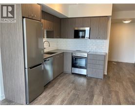 A kitchen with a refrigerator, oven, and microwave.