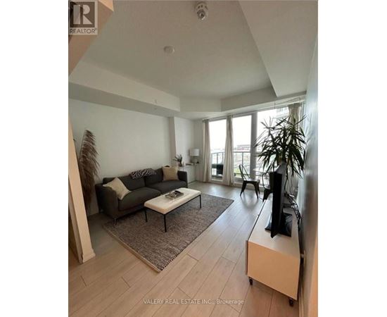 A living room with a couch, coffee table, and television.