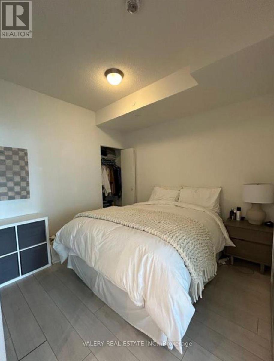 A bedroom with a bed, nightstand, and lamp.