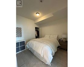 A bedroom with a bed, nightstand, and lamp.