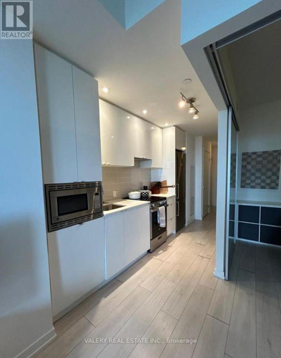 A modern kitchen with white cabinets and a black oven.