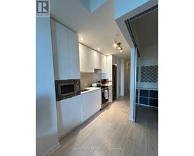 A modern kitchen with white cabinets and a black oven.