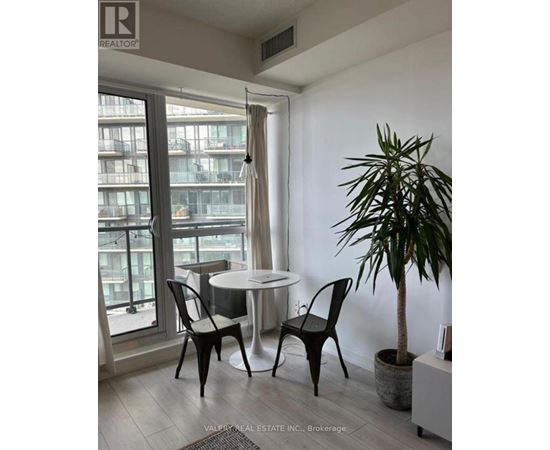 A living room with a table and chairs and a plant.