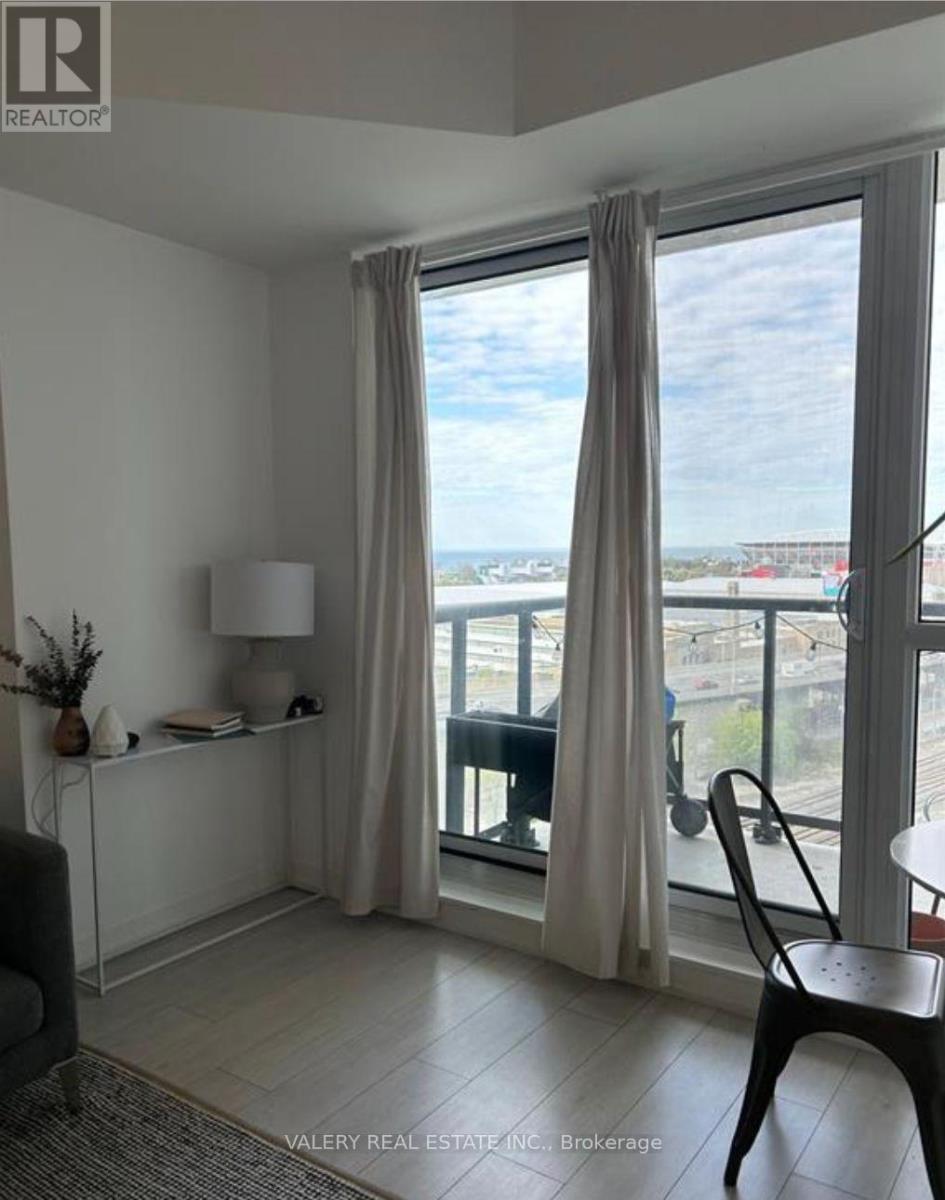 A room with a balcony overlooking a cityscape.