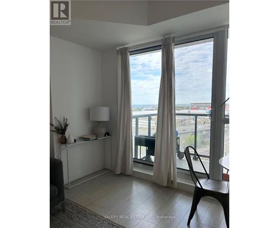 A room with a balcony overlooking a cityscape.