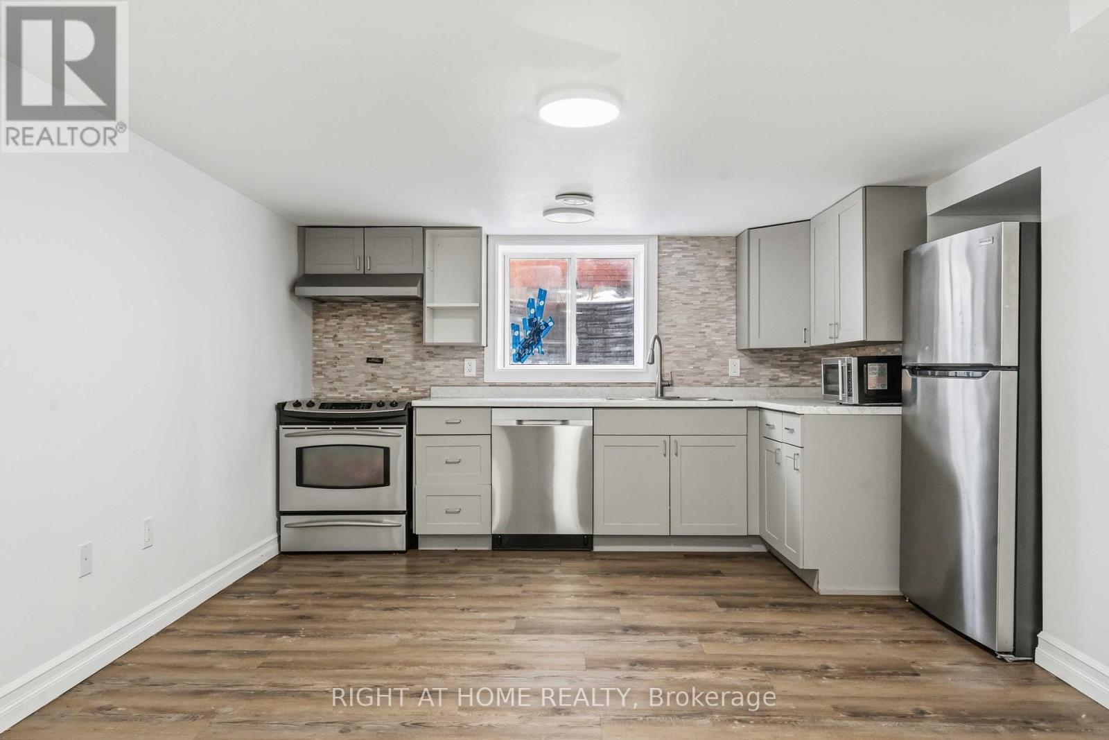 A kitchen with a stove top oven, dishwasher, and refrigerator.