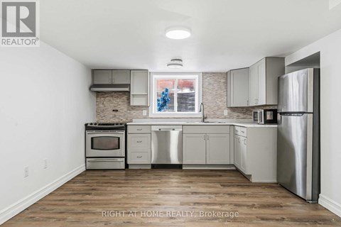 A kitchen with a stove top oven, dishwasher, and refrigerator.