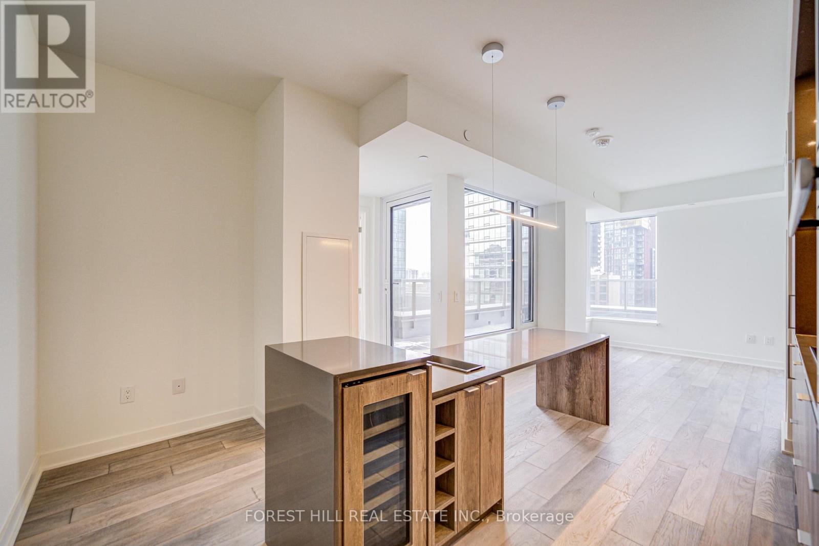 A spacious living room with a wooden cabinet and a glass table.